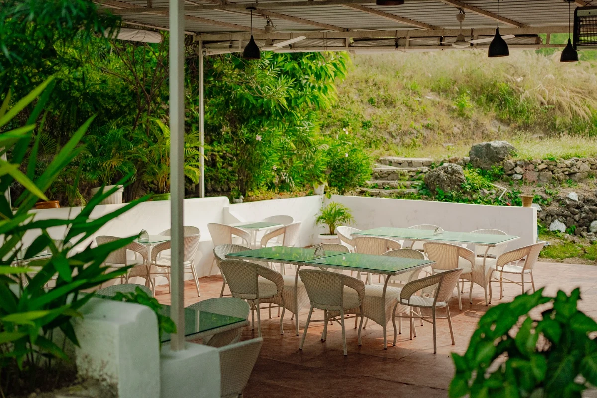 The simple open-air dining and sitting spaces of the Adhiroha ashram