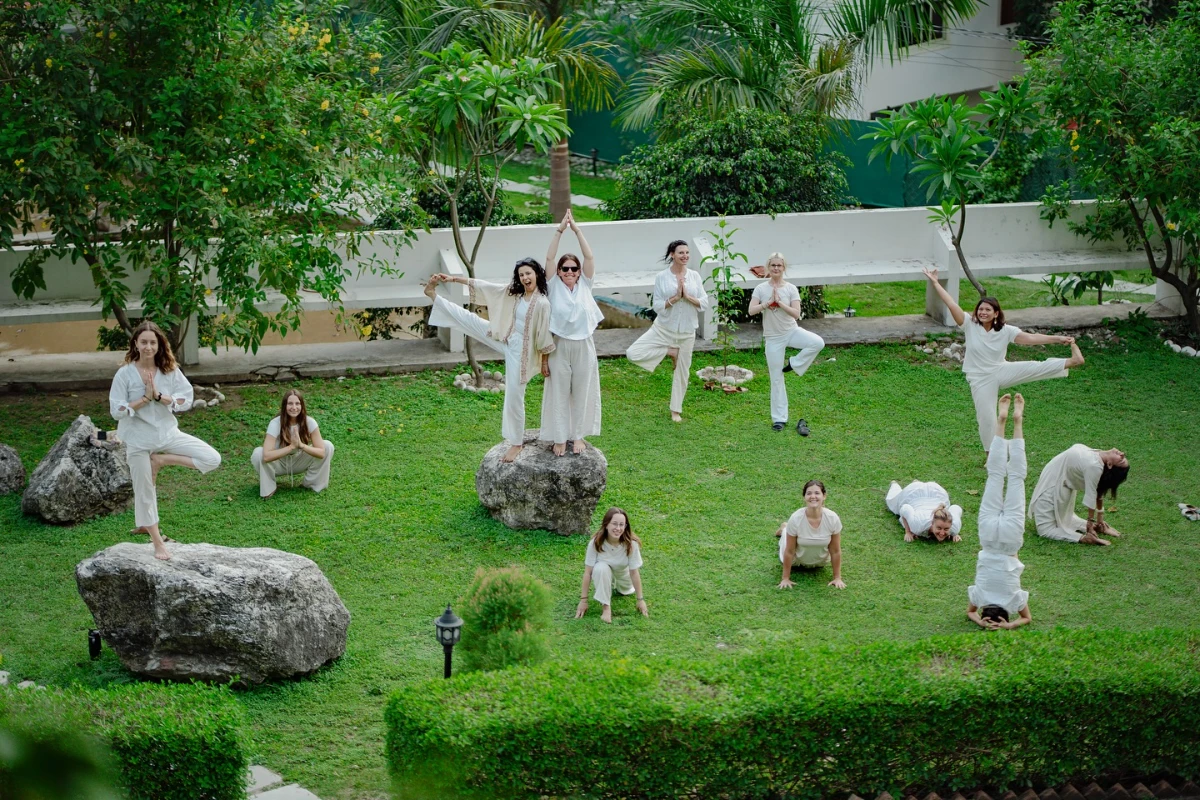 Participants practising asana among the boulders of the ashram garden