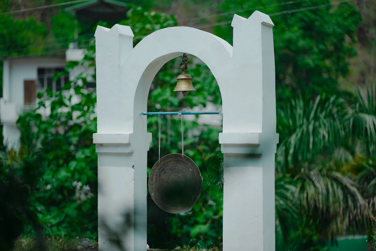 A singing bowl beneath the garden archway at the ashram