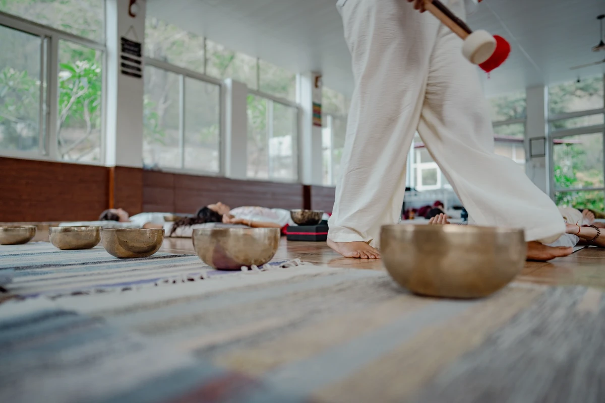 Bowls laid out across the sunlit shala floor between practice sessions