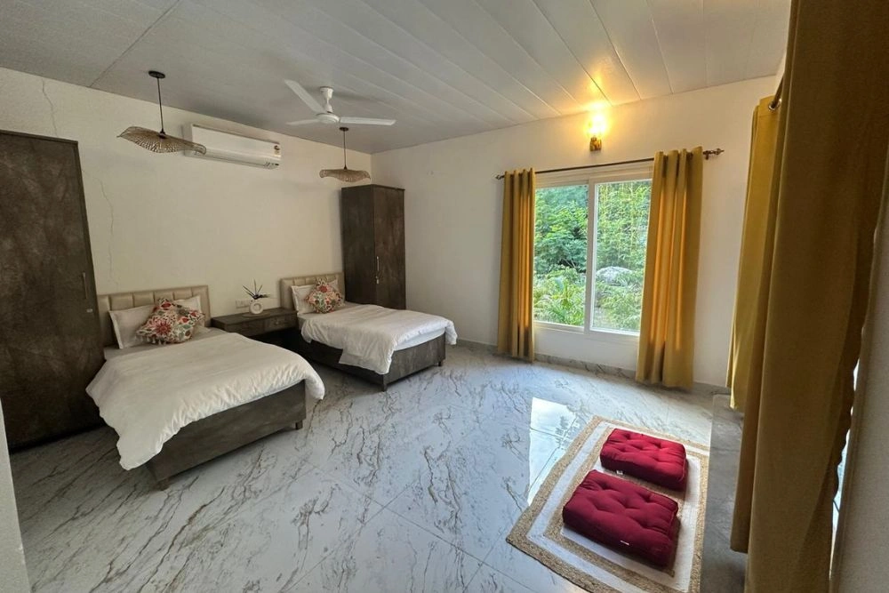 A clean, simple room with red meditation cushions and forest light