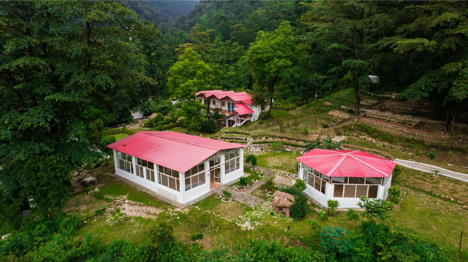 Aerial drone view of the Adhiroha shalas resting on the green hillside