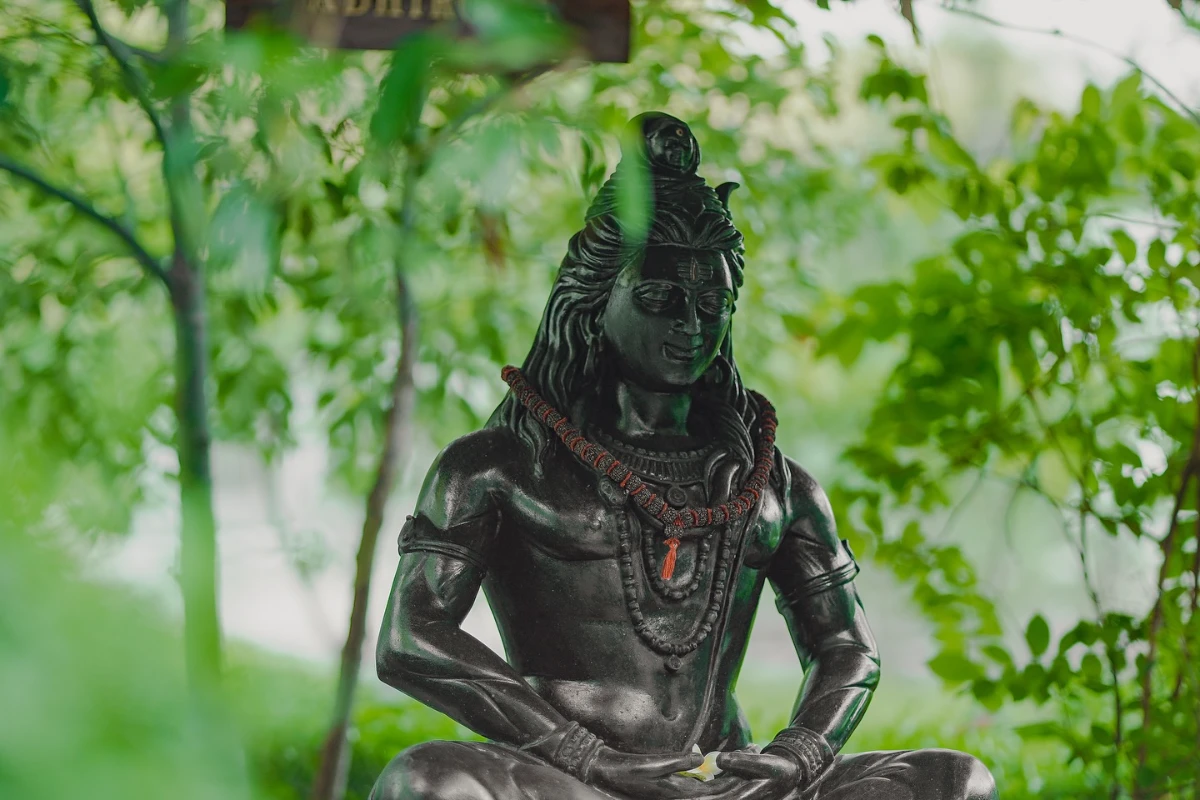 Statue of Lord Shiva amid green leaves on the Adhiroha ashram campus