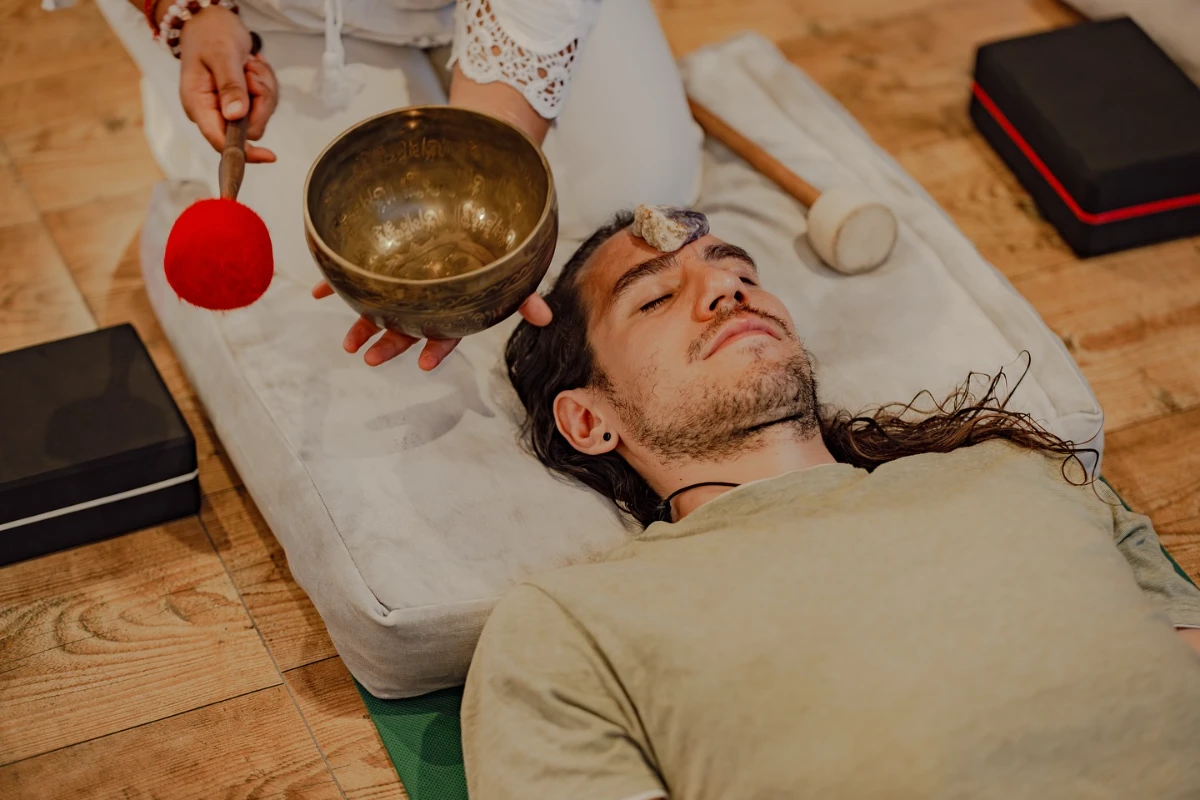 A Tibetan singing bowl played over a resting student during sound healing training