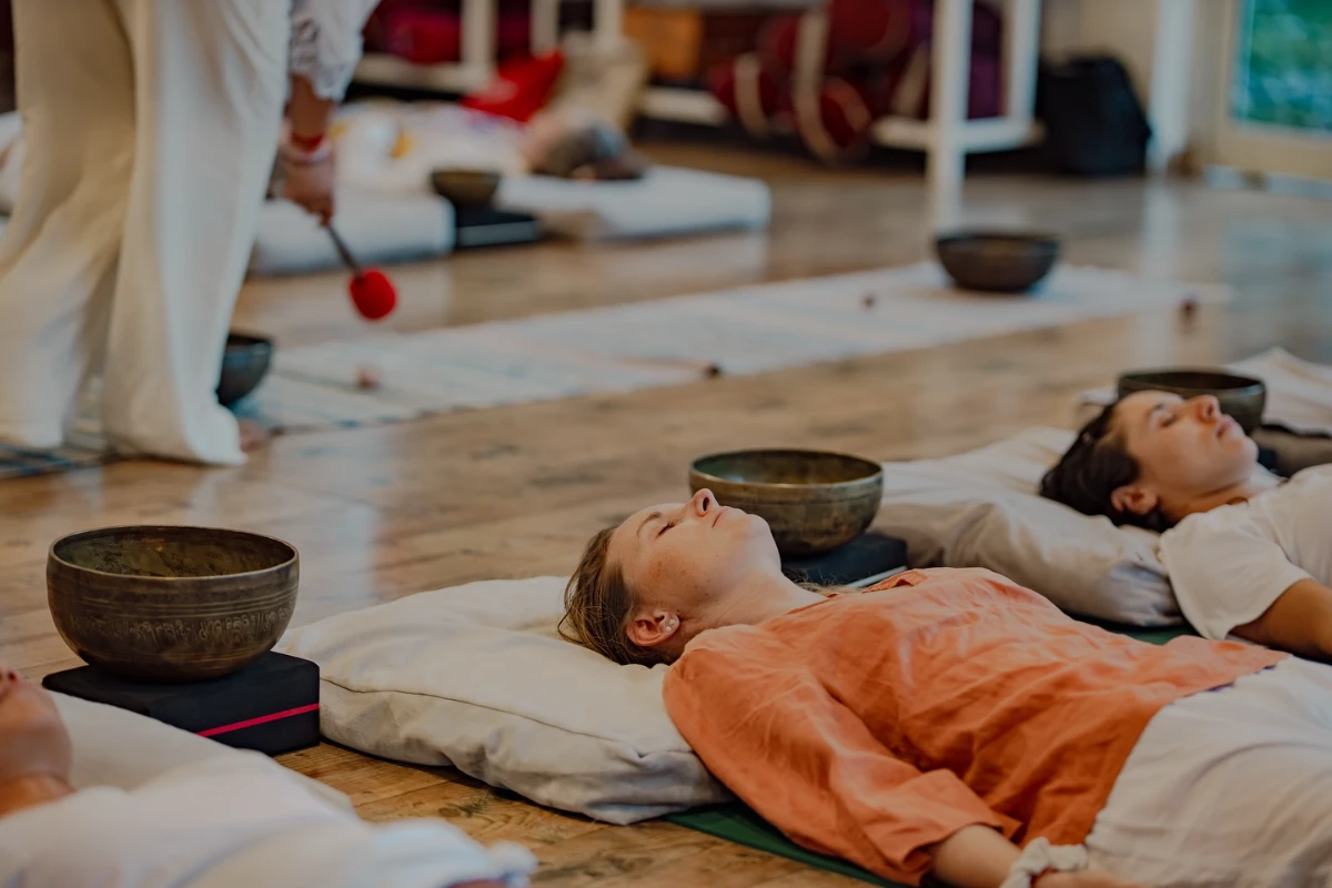 A singing bowl resting on a student&rsquo;s chest to balance the heart chakra