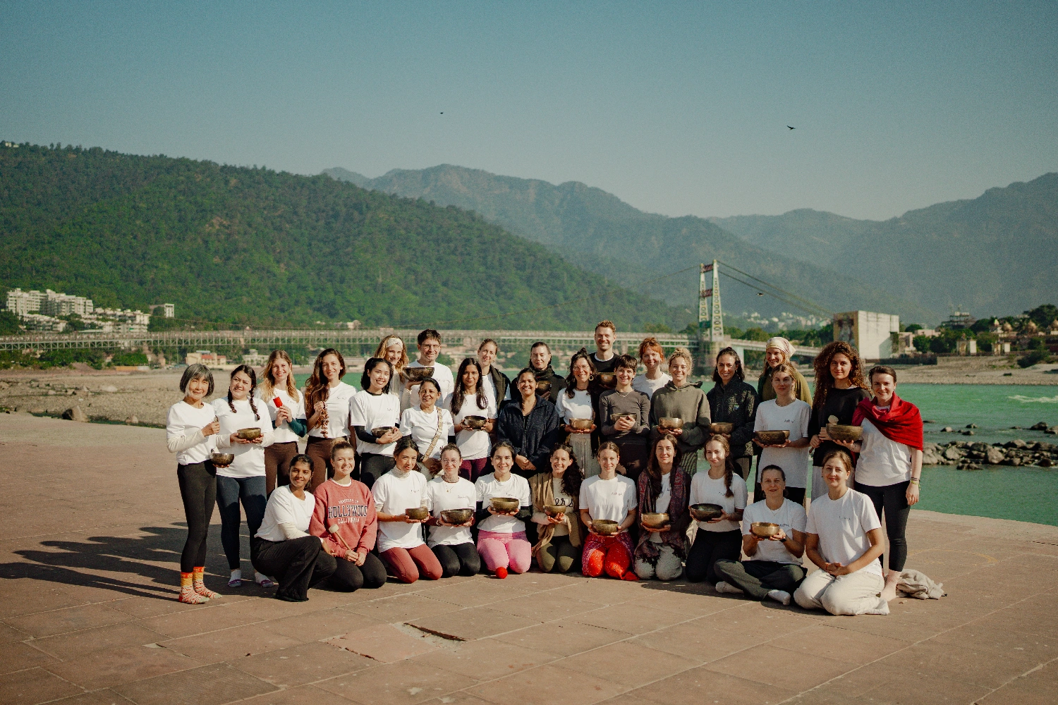 A group sound healing session by the Ganga Ji  with the Himalayan foothills behind