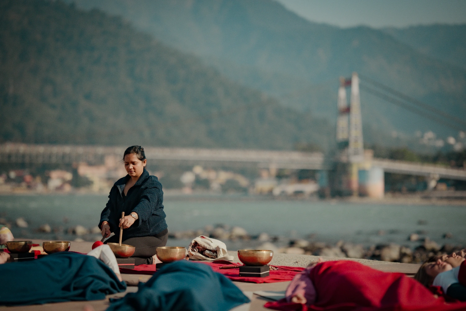 A sound healing session on the Ganga Ji  ghat with Laxman Jhula in the distance