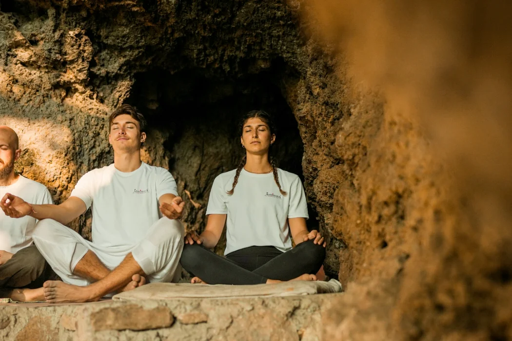 Two students meditating in the cool dark of the ancient Vasishta caves