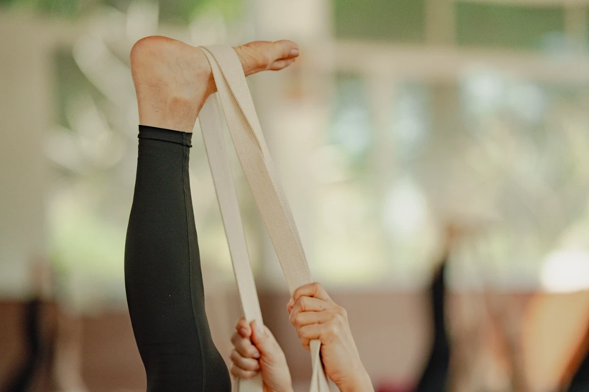 experienced yoga instructor guiding a student at Adhiroha